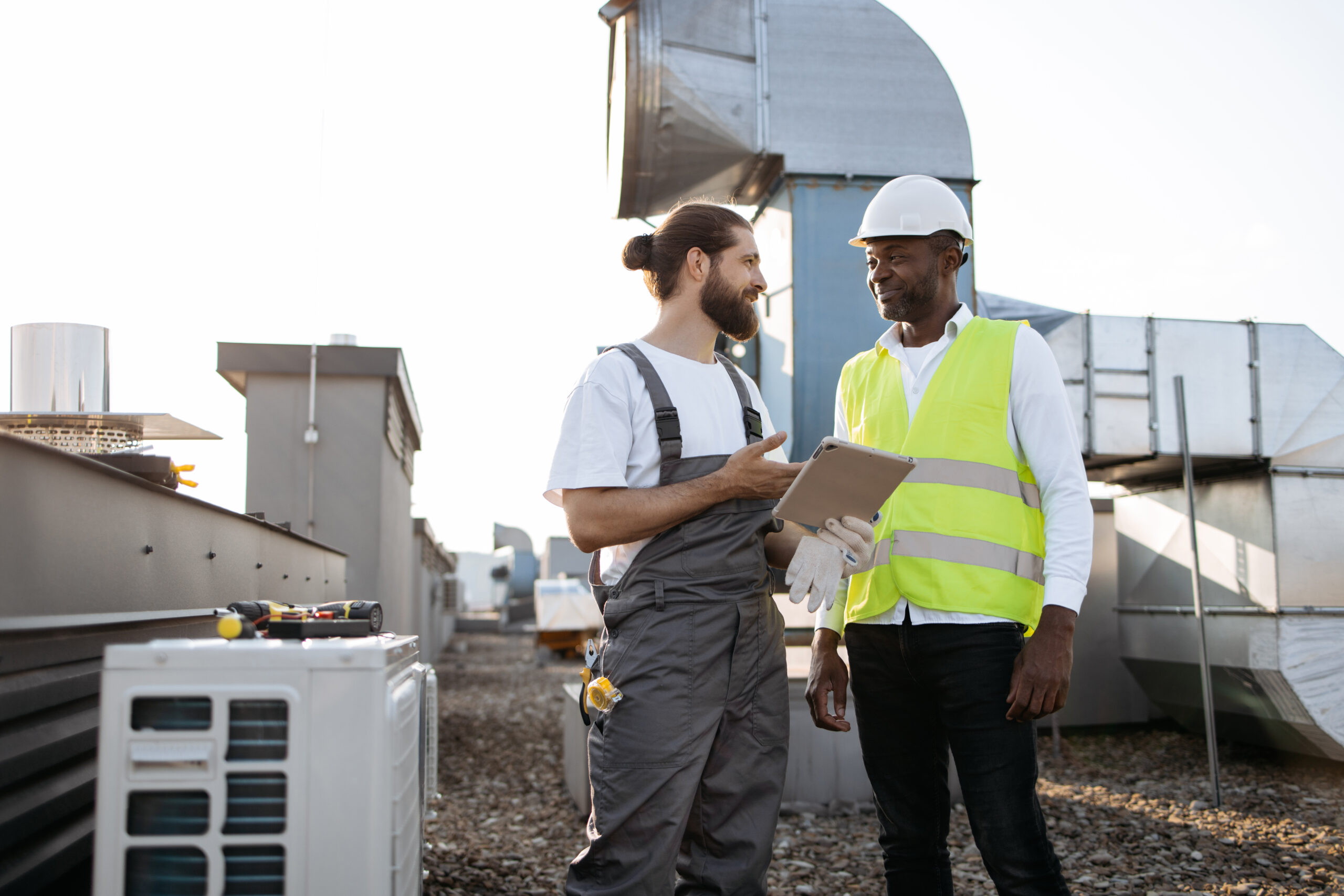 Two HVAC maintenance workers discussing what needs done.